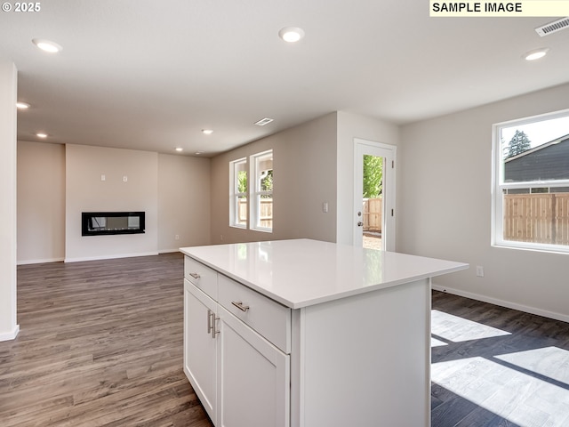 bedroom featuring an accent wall, visible vents, baseboards, light colored carpet, and wallpapered walls