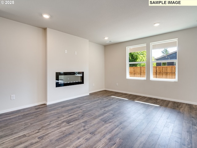 kitchen featuring a breakfast bar area, white cabinetry, a center island, stainless steel appliances, and dark wood-style flooring