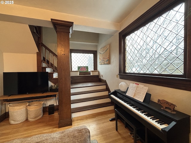 staircase with decorative columns and hardwood / wood-style floors