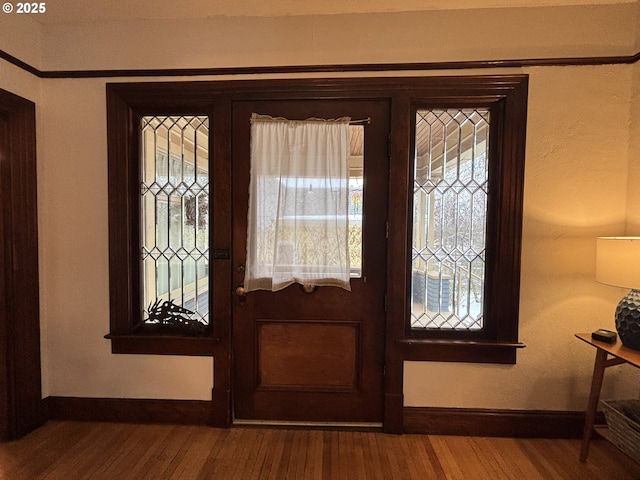 foyer entrance featuring wood finished floors and baseboards