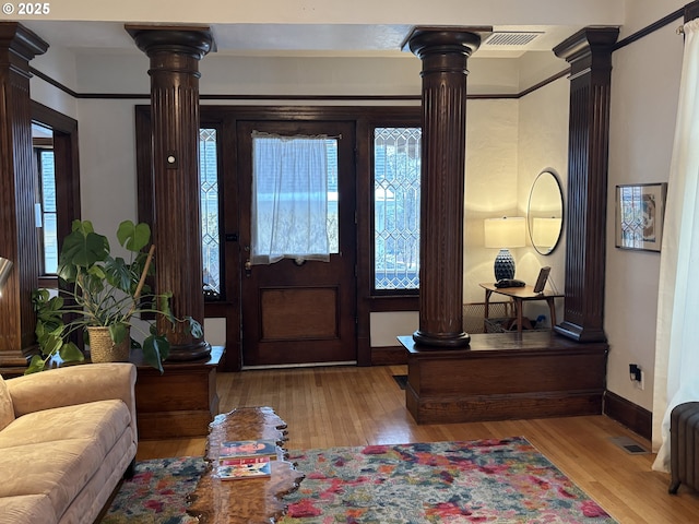 entrance foyer with wood finished floors and ornate columns