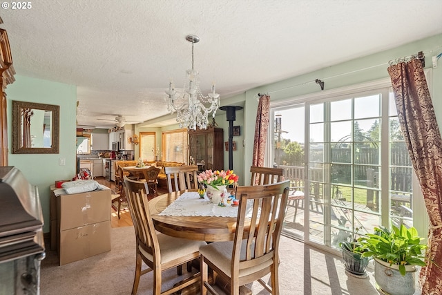 dining area featuring an inviting chandelier, light carpet, and a textured ceiling