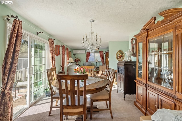 dining area with a wall mounted air conditioner, a textured ceiling, light colored carpet, and an inviting chandelier