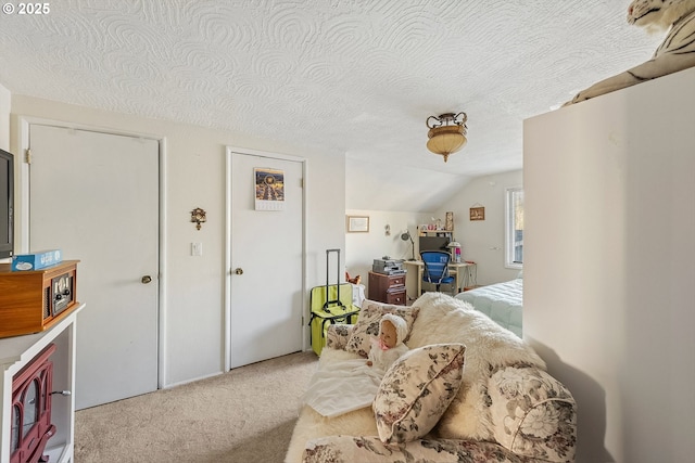 bedroom featuring vaulted ceiling, a textured ceiling, and light carpet
