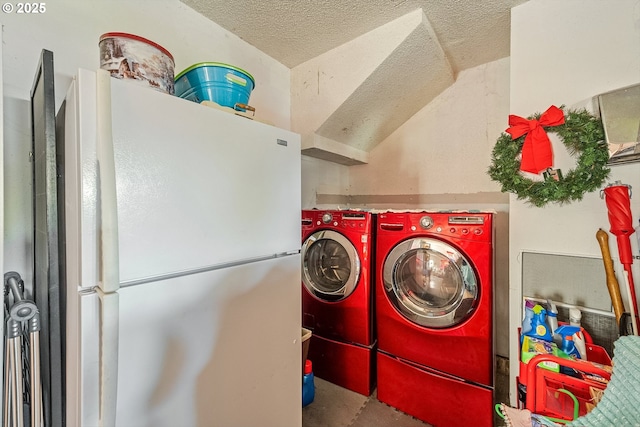 laundry area with washing machine and clothes dryer and a textured ceiling
