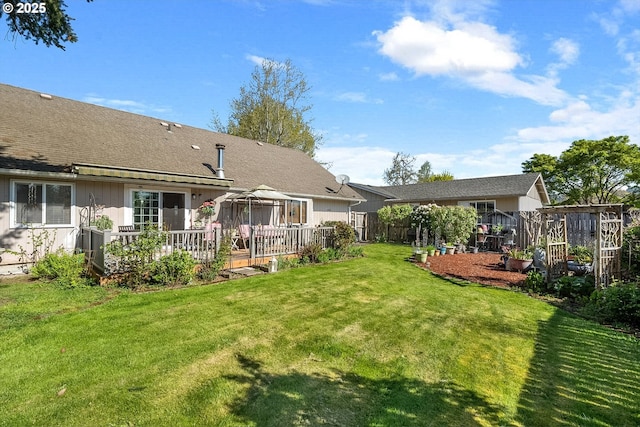 back of house featuring a gazebo, a yard, a wooden deck, and fence