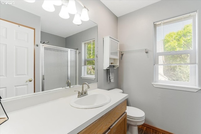 full bath featuring vanity, a stall shower, a notable chandelier, and toilet