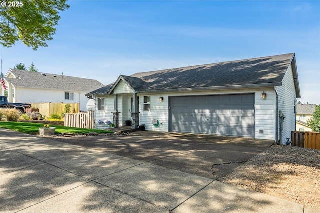 ranch-style home featuring fence, driveway, roof with shingles, and a garage