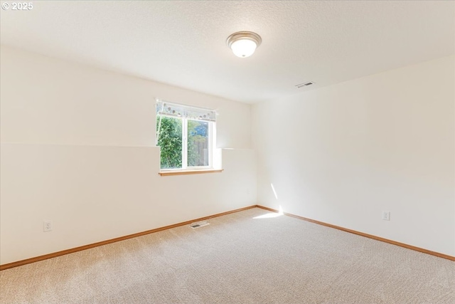 empty room featuring baseboards, visible vents, and carpet