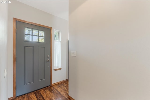 entryway featuring baseboards and dark wood-style floors