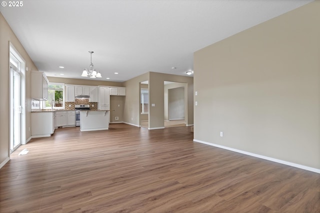 18407 NE 20th St, Vancouver, WA 98684 - unfurnished living room with a chandelier, baseboards, wood finished floors, a sink, and recessed lighting