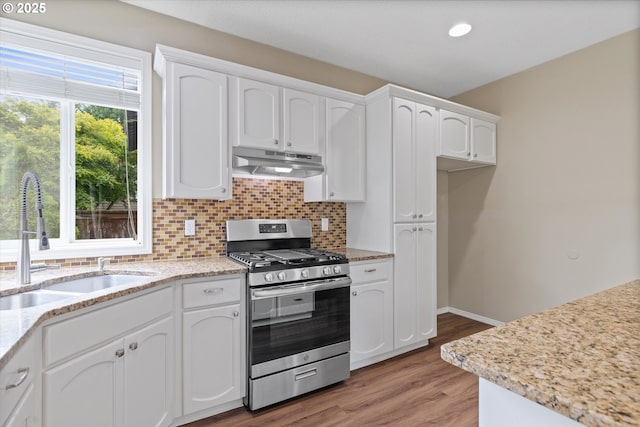 18407 NE 20th St, Vancouver, WA 98684 - kitchen with stainless steel gas range, under cabinet range hood, a sink, white cabinetry, and tasteful backsplash