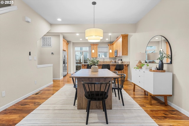 dining space with recessed lighting, wood finished floors, visible vents, and baseboards