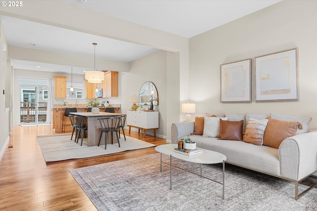 living area featuring light wood-style flooring and baseboards