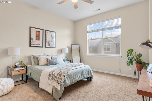 carpeted bedroom featuring a ceiling fan, visible vents, and baseboards