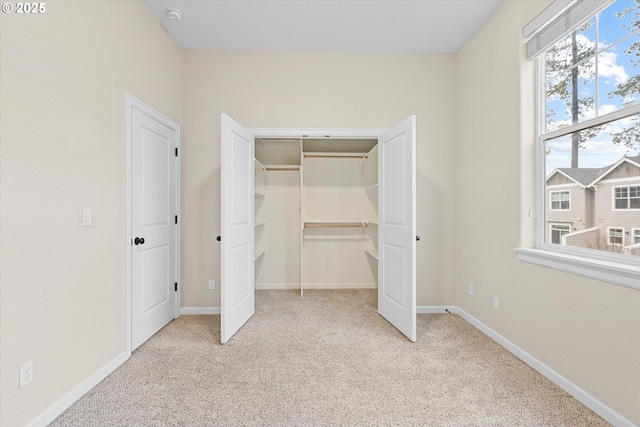 unfurnished bedroom with carpet floors, baseboards, and a closet