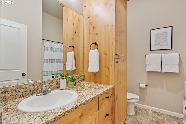 bathroom featuring toilet, baseboards, a shower with shower curtain, and vanity