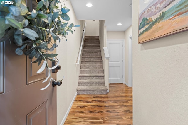 foyer featuring recessed lighting, stairway, baseboards, and wood finished floors