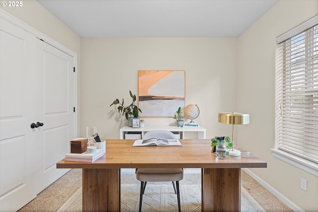 carpeted home office featuring baseboards