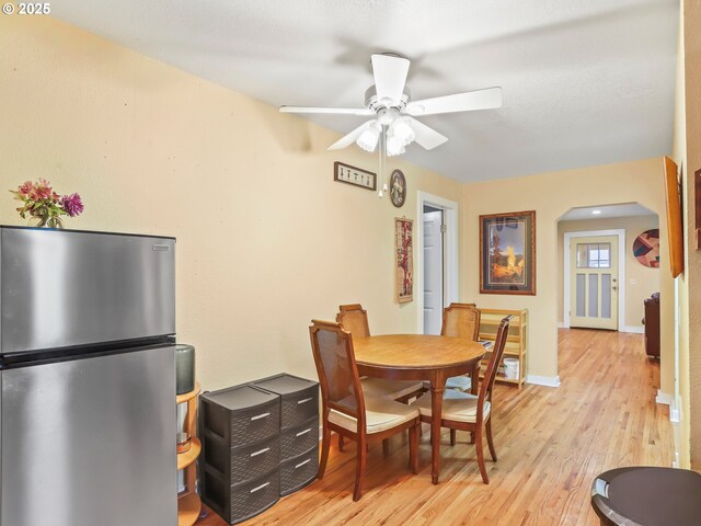 dining area with light hardwood / wood-style flooring and ceiling fan