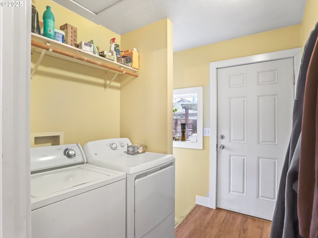 clothes washing area featuring hardwood / wood-style floors and independent washer and dryer