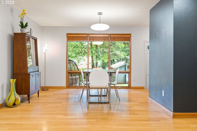 dining room with light wood-type flooring and baseboards