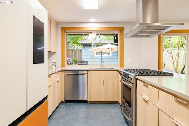 kitchen featuring island exhaust hood, a sink, light countertops, light brown cabinets, and stainless steel appliances