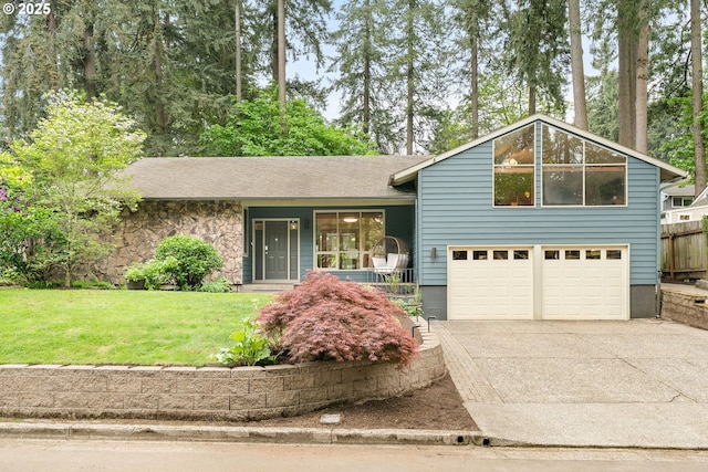 split level home with covered porch, an attached garage, concrete driveway, and a front yard