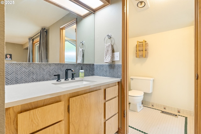 bathroom with vanity, toilet, tile patterned floors, and tasteful backsplash