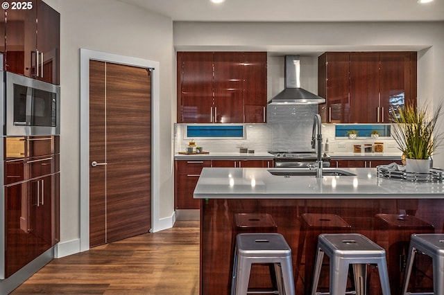 15192 SW Huntwood St, Tigard, OR 97224 - kitchen with wall chimney exhaust hood, stainless steel microwave, modern cabinets, a breakfast bar, and dark wood-type flooring