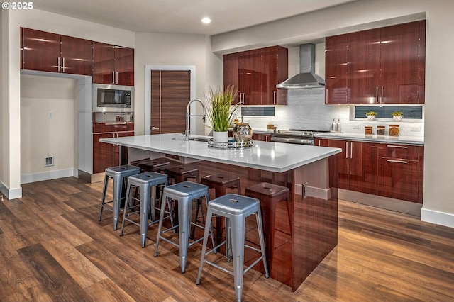 15192 SW Huntwood St, Tigard, OR 97224 - kitchen featuring wall chimney range hood, modern cabinets, appliances with stainless steel finishes, dark wood-type flooring, and recessed lighting