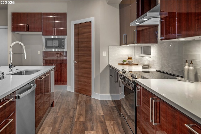 15192 SW Huntwood St, Tigard, OR 97224 - kitchen with stainless steel appliances, wall chimney exhaust hood, dark wood-style floors, modern cabinets, and backsplash