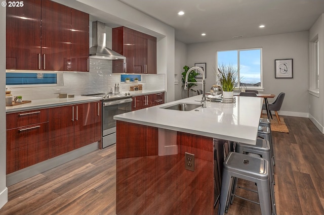 15192 SW Huntwood St, Tigard, OR 97224 - kitchen with modern cabinets, electric range, wall chimney exhaust hood, dark wood-style floors, and a kitchen bar