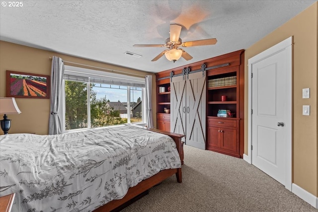 1609 Wood Duck St, Silverton, OR 97381 - bedroom with carpet floors, a barn door, a textured ceiling, and a ceiling fan