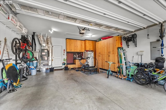 1609 Wood Duck St, Silverton, OR 97381 - garage with electric panel, a garage door opener, and freestanding refrigerator