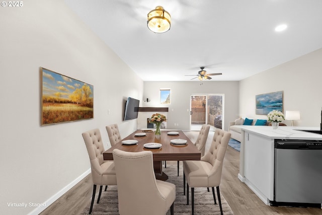 dining room with light wood-style floors, baseboards, and ceiling fan