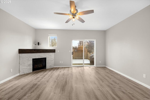 unfurnished living room with baseboards, wood finished floors, and a fireplace