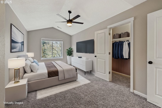 carpeted bedroom featuring visible vents, lofted ceiling, a spacious closet, a closet, and a textured ceiling