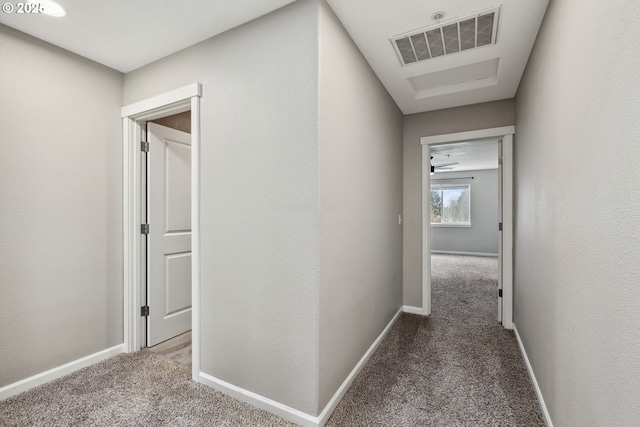 hall featuring carpet flooring, baseboards, and visible vents