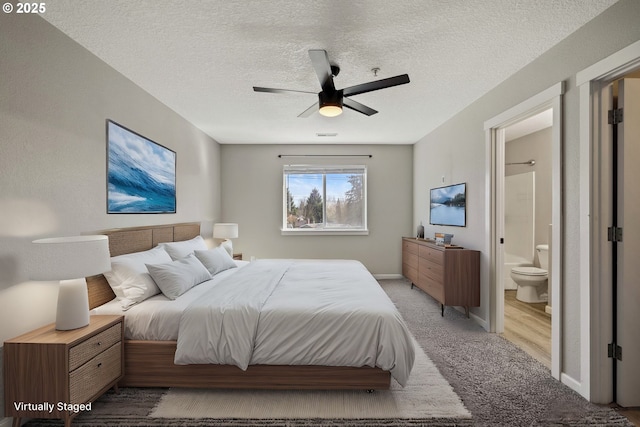 bedroom featuring baseboards, a textured ceiling, ensuite bathroom, and carpet