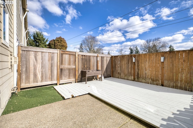 wooden terrace with a fenced backyard