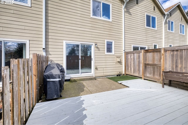 rear view of house with a wooden deck and a fenced backyard