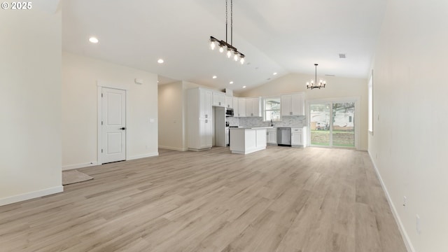 unfurnished living room with lofted ceiling, an inviting chandelier, and light hardwood / wood-style flooring