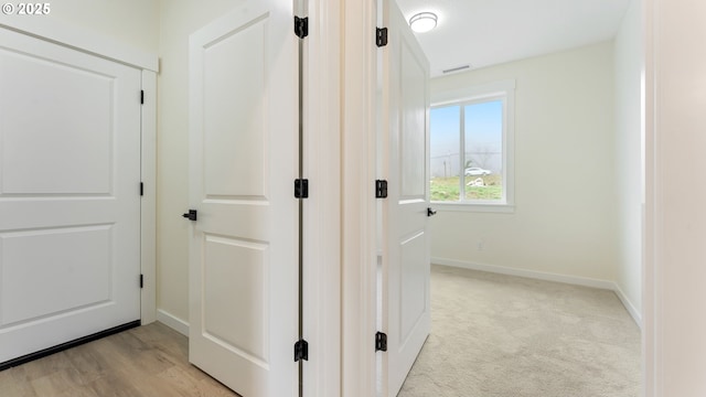 hallway with light colored carpet