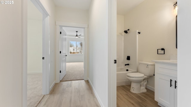 full bathroom with toilet, vanity, bathtub / shower combination, and hardwood / wood-style floors