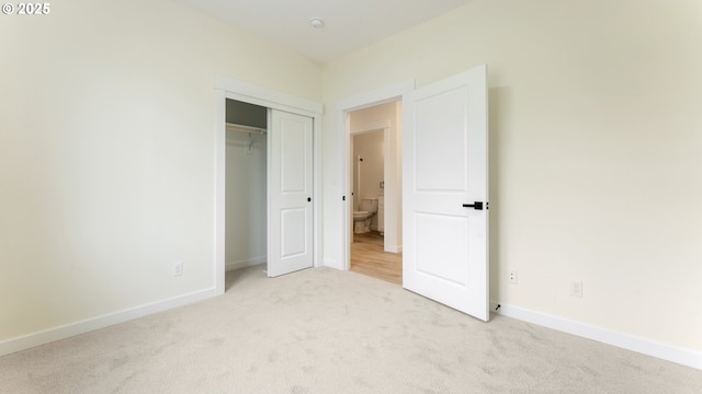 unfurnished bedroom featuring a closet and light carpet