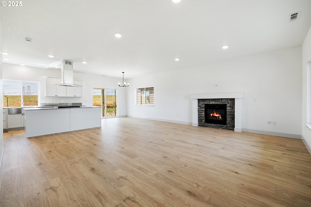 534 Grant St, Umatilla, OR 97882 - unfurnished living room featuring a chandelier, light wood finished floors, recessed lighting, a fireplace, and a sink