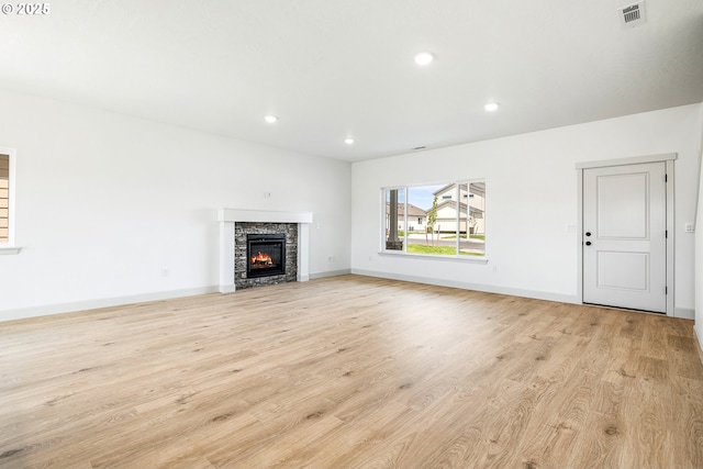 534 Grant St, Umatilla, OR 97882 - unfurnished living room with light wood-style flooring, recessed lighting, a stone fireplace, and baseboards