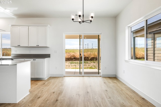 534 Grant St, Umatilla, OR 97882 - unfurnished dining area with light wood finished floors, a chandelier, and baseboards
