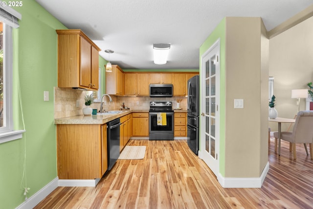 1601 NW 2nd Ave, Battle Ground, WA 98604 - kitchen featuring stainless steel appliances, a sink, light countertops, decorative backsplash, and light wood finished floors